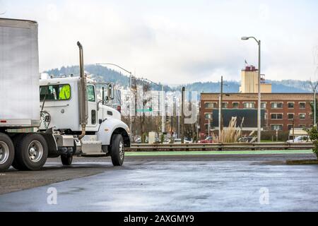 White Bonnet Big Rig lokaler Diesel-Sattelschlepper mit Tageskabine, die Commercial Cargo für die Lieferung im trockenen Transporter transportiert, der auf dem Stor steht Stockfoto