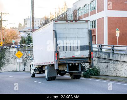 White Bonnet Big Rig Langstreckendiesel-Sattelschlepper mit Tageskabine, die Commercial Cargo for Delivery in Kastenanhänger transportiert, der mit Hubantrieb ausgestattet ist Stockfoto