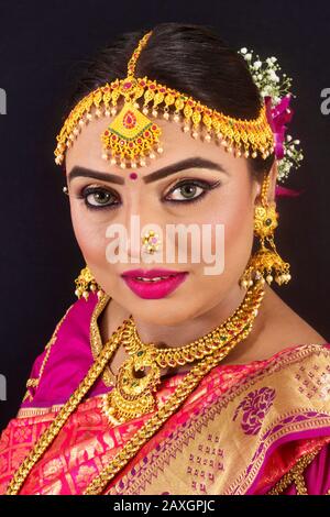 Porträt einer jungen und schönen indianischen bengalischen Brunette-Frau in Rot und Weiß traditionelle ethnische Sari Stockfoto