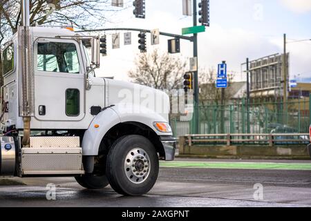 White Bonnet Big Rig lokaler Diesel-Sattelschlepper mit Tageskabine, die Commercial Cargo für die Lieferung im trockenen Transporter transportiert, der auf dem Stor steht Stockfoto