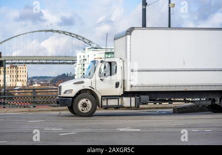 Kompakter, weißer Flurförderwagen für mittlere Beanspruchung für lokale Lieferungen, die kommerzielle Fracht transportieren, um sie rechtzeitig in einem trockenen Kastenwagen zu liefern Stockfoto