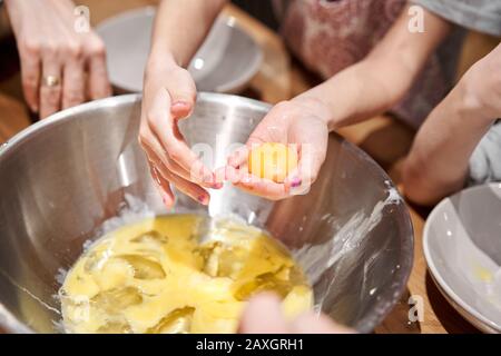 Trennen Sie das Ei in Protein und Eigelb. Lustige Meisterklasse für Kinder zum Backen von Pizza und italienischem Eis. Kleine Kinder lernen zu kochen. Kinder Stockfoto