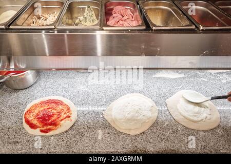 Halbfertige Produkte zum Kochen von Pizza in kalten Tisch für Rohlinge füllen. Traditioneller Holzofen im Restaurant, Italien. Originale neapolitanische Pizza. Rot Stockfoto
