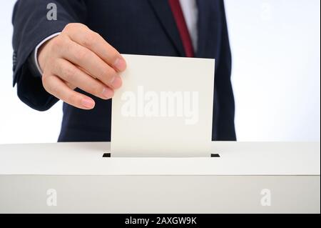 Die Hand des Mannes auf dem Stimmzettel in die Wahlurne. Stockfoto