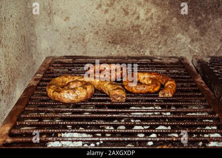 Traditionelle hausgemachte Würstchen gegrillte Kohle und Feuer, traditionelle Küche, Argentinien. Stockfoto