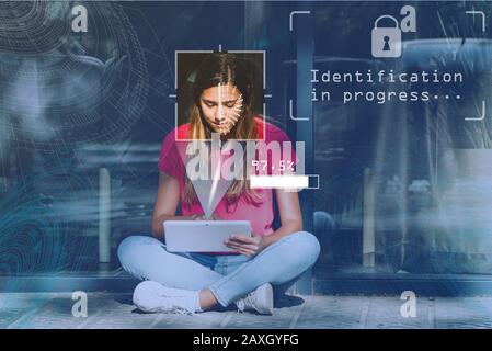 Gesichtserkennungskonzept: Ein gescanntes Gesicht, ein Passwortkennzeichen auf futuristischem Hintergrund. Überwachung der jungen Frau mit einer Kamera Stockfoto