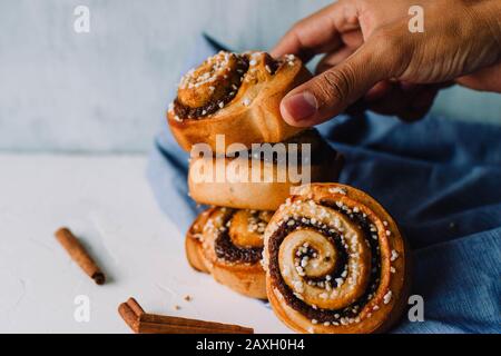 Handfest Zimtrollen auf weißem Hintergrund Stockfoto