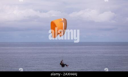 Pacific City, Oregon USA - 07. Juli 2019: Ein Mann, der einen Gleitschirm über den Naturraum Cape Kiwanda State fliegt. Stockfoto