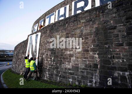 Carmarthen, Großbritannien. Februar 2020. Mitglieder des Extinction Rebellion in Carmarthen entfachen Banner, die "Act Now" ("Gweithredwch Nawr" auf walisisch) auf den Seiten der County Hall in Carmarthen lesen. Kredit: Gruffydd Ll. Thomas/Alamy Live News Stockfoto