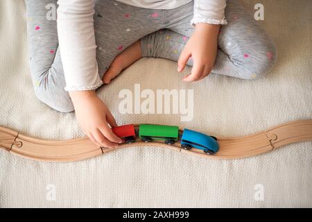 Kinderhände, die mit Holzspielzeug auf der Bahn spielen. Nahaufnahme. Stockfoto