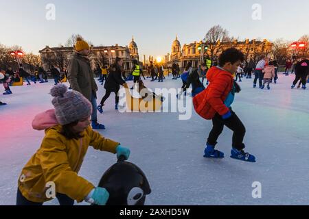 England, London, Greenwich, Erwachsene und Kinder Eislaufen im Queens House Ice Rink Stockfoto