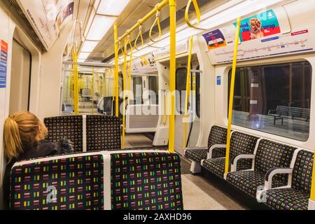 England, London, Metropolitan Underground Train, Single Female Passenger in Empty Carriage Stockfoto