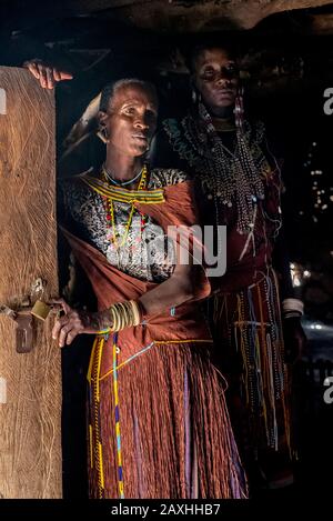 Tätowierte afrikanische Frau in Gedanken verloren. Aufgenommen während eines Besuchs in einem lokalen Boma in der Nähe des Lake Eyasi. Stockfoto