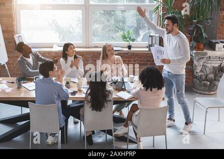 Junger Manager jubelt sein junges Business-Team auf Stockfoto