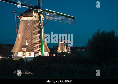 Wunderschönes Landschaftsbild von drei beleuchteten Windmühlen in einer Reihe Stockfoto