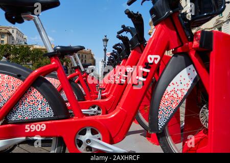 Barcelona, SPANIEN - 07. Juni 2019: Horizontaler Schuss des Straßenverkehrs Red Hybrid mieten Fahrräder mit elektronischer Zahlungsart für Reisende aroun Stockfoto