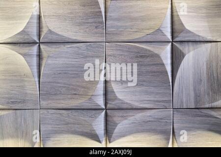 3D-Zierwand mit imitierter Holzstruktur für das Innere einer ungewöhnlichen geometrischen Form. Graubrauner heller Hintergrund mit einem Muster, das a imitiert Stockfoto