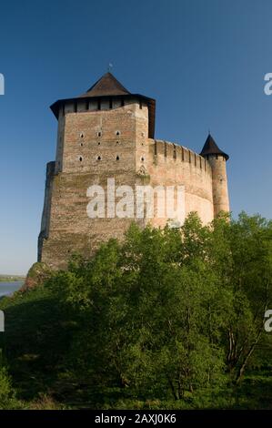 Festung Khotyn vor blauem Himmel. Grünes Laub im Vordergrund. Stockfoto