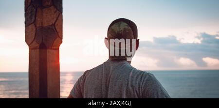 Der Mann blickt über das Meer und findet Frieden. Freiheitskonzept. Stockfoto