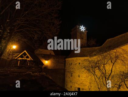 Der Turm und die beleuchtete Stadtmauer Rothenburgs nachts Stockfoto