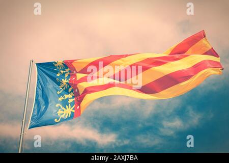 Flagge der Comunidad Valenciana, Region in Spanien. Bewegung im Wind. Querverarbeiteter Farbton - gefilterter Retro-Look. Stockfoto