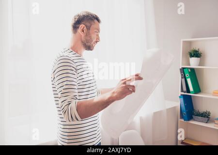 Architekt, der Blaupause hält und sich das Projektschema ansieht Stockfoto