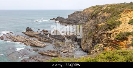 Felsige zerklüftete Küste in der Nähe des Fischerhafendorfs Azenha do Mar, Alentejo Littoral, Portugal, Südeuropa Stockfoto