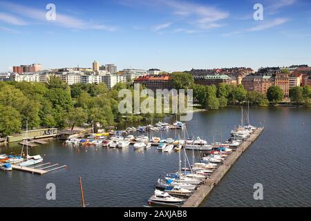 Stockholm, Schweden. Blick auf die Insel Kungsholmen von der riesigen Vasterbron-Brücke. Yachts im Yachthafen. Stockfoto