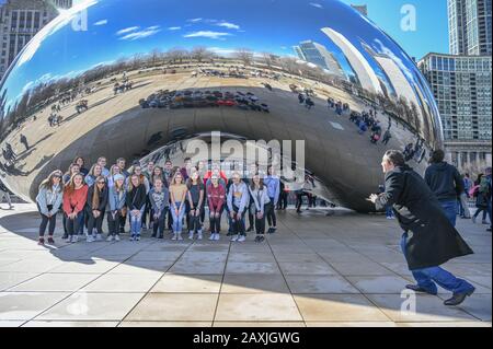 Touristen bewundern das kultige Cloud Gate im Millenium Park Anfang Frühjahr in Chicago, Illinois.Chicago ist die drittbevölkerungsreichste Stadt der USA. Stockfoto