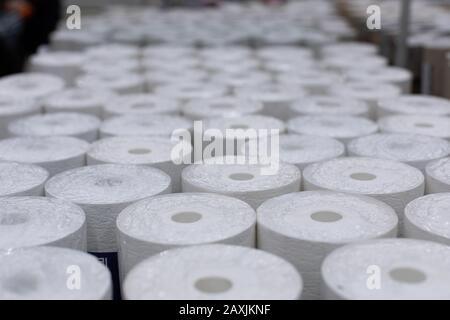 Viele Brötchen mit Tapeten, Hintergrundkulisse und Dekorationsdesign. Weiße Tapete in Rollen zur Dekoration von Wänden und Reparaturen in Kunststoffverpackungen. Wareho Stockfoto