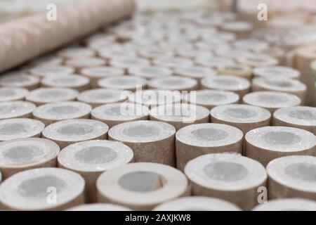 Viele Brötchen mit Tapeten, Hintergrundkulisse und Dekorationsdesign. Beige Tapete zum schmücken von Wänden und Reparaturen, die in Rollen in Kunststoffverpackungen verdreht sind Stockfoto