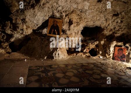 Religiöse Ikonen in einer Höhle im Inneren des griechischen orthodoxen Heiligen Klosters von Sarantarion Mountain oder Die Versuchung, die an den hängen des Mount of Temptation gebaut wurde, die sich entlang einer Klippe mit Blick auf die Stadt Jericho in den palästinensischen Gebieten in der Nähe des Jordan im Westjordanland, Israel, befindet Stockfoto