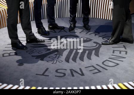 Berlin, Deutschland. November 2019. Männer stehen bei der Eröffnung des Besucherzentrums des Bundesnachrichtendienstes (BND) auf einem Teppich mit dem Logo des Geheimdienstes. Nach den Enthüllungen über die jahrzehntelange Spionage ausländischer Staaten durch die Geheimdienste BND und CIA fordern Parlamentsmitglieder in Deutschland und der Schweiz Aufklärung. Kredit: Wolfgang Kumm / dpa / Alamy Live News Stockfoto