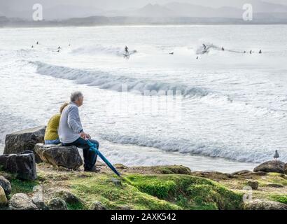 Australien, Queensland, Pazifik, Senioren beobachten Surfer Stockfoto