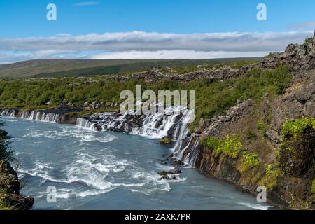 Kleiner Wasserfall in Island - Hraunfossar - an einem sonnigen Tag während der Sommerzeit Stockfoto