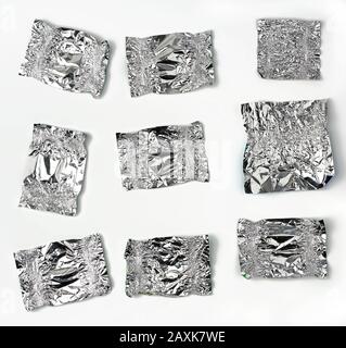 Verschiedene zerknitterte Folien verwendeten Süßigkeiten-Wrapper auf weißem Hintergrund, Draufsicht Stockfoto