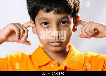 Mumbai, Maharashtra, Indien - Asien, 30. September 2006 - Concept Portrait Indian Cute Little Boy schließt seine Ohren mit Fingern. Stockfoto