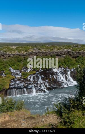 Kleiner Wasserfall in Island - Hraunfossar - an einem sonnigen Tag während der Sommerzeit Stockfoto