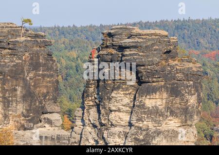 Felsen in der Sächsischen Schweiz. Abenteuer zum Wandern und Klettern in der Nähe der Bastei-Brücke im Elbtal. Sonnenschein und blauer Himmel mit Bäumen im Herbst Stockfoto