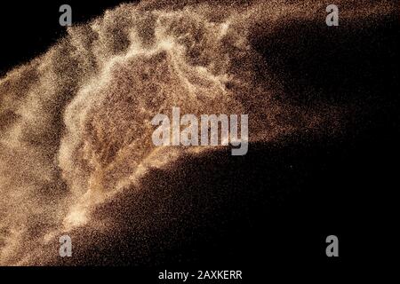 Braune Sandspritzer.trockene Flusssandexplosion isoliert auf schwarzem Grund. Abstrakte Sandwolke. Stockfoto