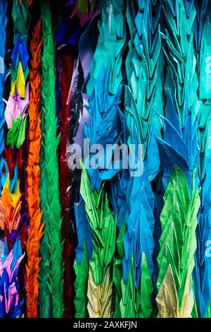 Nahaufnahme der farbenfrohen Origami-Kräne, ein Symbol des Friedens, die einen Altar schmücken. Stockfoto