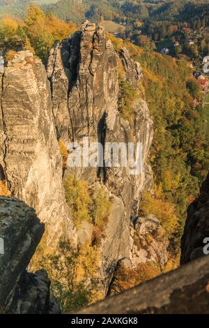 Blick auf die Felsen im Elbsandsteingebirge von der Bastei-Brücke. Felsformation, Sonnenschein, Bäume und Häuser mit dem Elbtal. Klettern Stockfoto