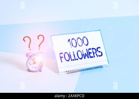 Textzeichen mit 1000 Followern. Geschäftsfoto, auf dem die Anzahl der Personen gezeigt wird, die jemand im Instagram Mini-Wecker neben einem Pape folgt Stockfoto