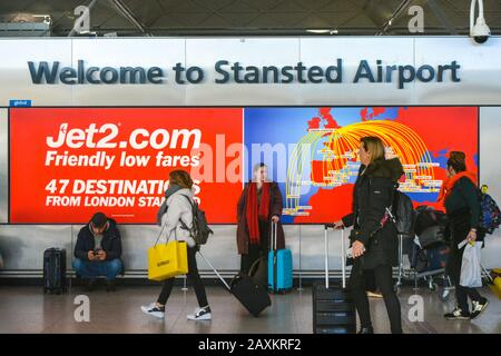 London Stansted Airport STN, Großbritannien Großbritannien, 18.01.20 - Eingang des internationalen Flughafens. Verschwommene Wanderpassagiere mit Rollwagen und Handshoppen Stockfoto