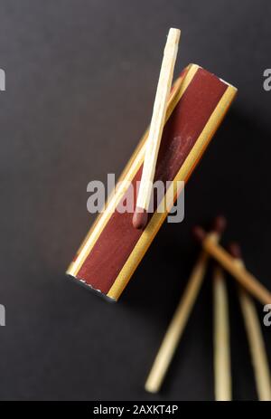 Matchstick auf Matchbox über schwarzem Hintergrund. Feuer aus. Draufsicht, Platz für Text, Werbung. Stockfoto