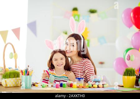 Nahaufnahme von zwei hübschen hübschen hübschen charmanten fröhlichen fröhlichen Mädchen kleine Tochter mit bunt angeschnallten Ohren, die Handarbeit umarmend machen Stockfoto