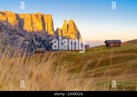 Sonnenaufgang über den Berggipfel und den Hütten im Herbst, Seiser Alm, in den Bergen der Berge, in den Bergen, in Südtirol, in Italien Stockfoto