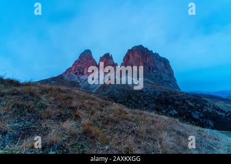 Herbstaufgang über den Bergen Sassolungo und Sassopiatto, Passo Sella, Gröden, Fassatal, in den Dolden, in Südtirol, Italien Stockfoto