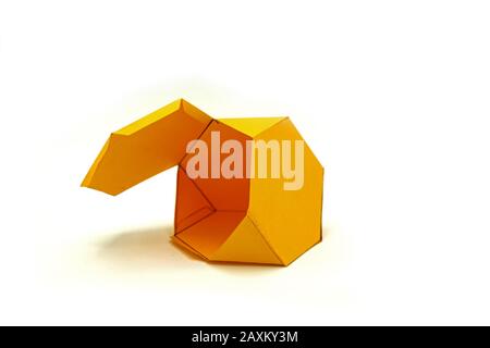 Geometrische Form aus gelbem Papier geschnitten und auf weißem Hintergrund fotografiert. Geometrienetz des Archimedischen Volumenkörpers Trunkiertes Tetraeder. 2-dimensionale n Stockfoto