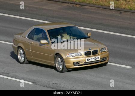 2002 Gold BMW 330 CI; Großbritannien Fahrzeugverkehr, Transport, moderne, Salonwagen, auf der Autobahn M61, Manchester, Großbritannien Stockfoto